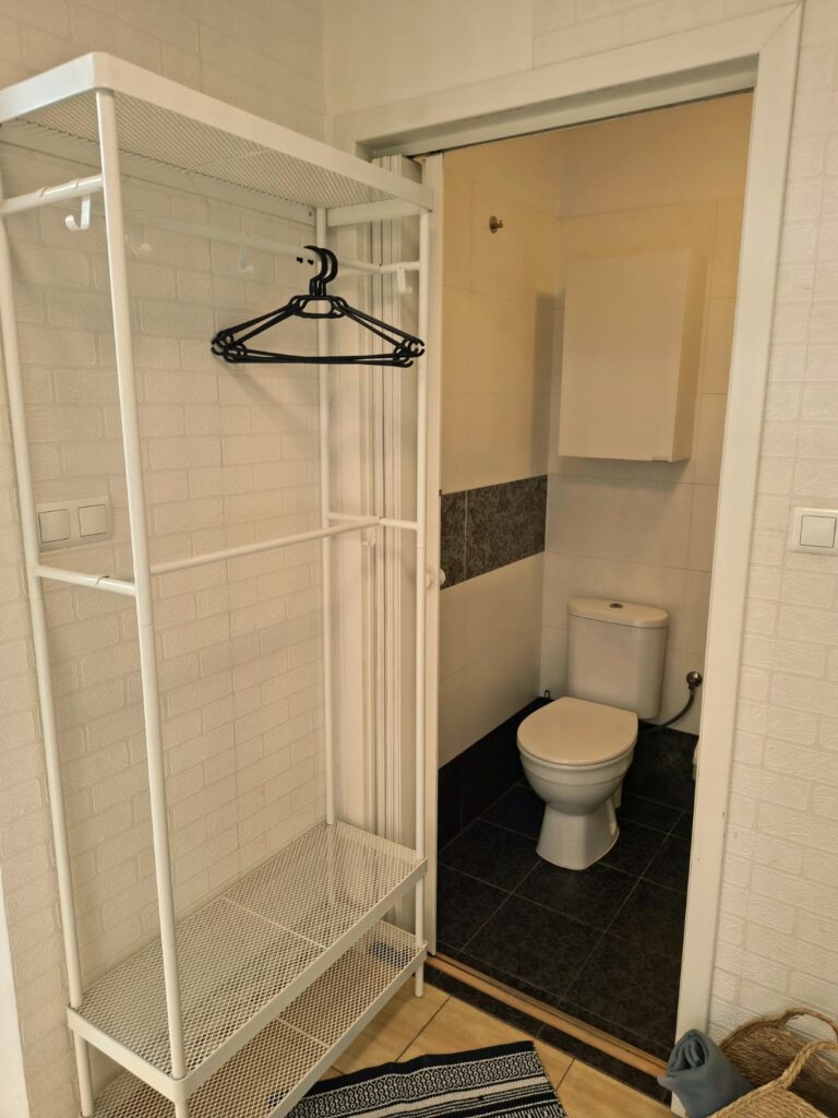 Praktyczny stojak na ubrania z wieszakiem i półką w pokoju jednoosobowym w obiekcie Villa NOVA w Dębkach