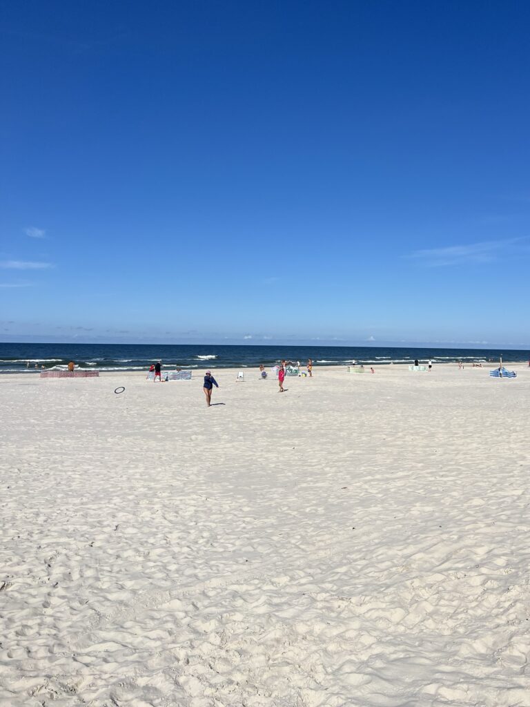Szeroka, piaszczysta plaża w Dębkach pod jasnym niebem