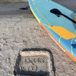 Deska SUP leżąca na piaszczystej plaży nad Bałtykiem w Dębkach